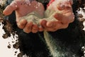 Sand is falling through a man`s fingers. A young adult holds a f Royalty Free Stock Photo