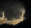 Sand flying explosion, Golden sand wave explode. Abstract sands cloud fly. Yellow colored sand splash throwing in Air. black Royalty Free Stock Photo