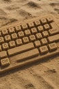 Sand keyboard: A computer keyboard sculpted from sand on a beach. A blend of technology and nature in a unique and creative Royalty Free Stock Photo