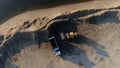 Sand mining industry, sand mine at the quarry. Scene. Aerial top view of a bulldozer machine putting sand to the truck