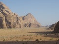 Sand, mountains and sparse vegetation in the Wadi Rum desert, Jordan Royalty Free Stock Photo