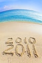 On sand at ocean edge it is written 2010-2011 Royalty Free Stock Photo