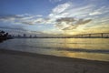 Sand and palm trees line the shore of Coronado Island as the sun slowly rises above the Coronado Bridge Royalty Free Stock Photo