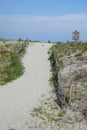 Sand pathway leading over a grassy beach sand dune with a spit rail wooden fence Royalty Free Stock Photo