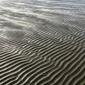 Sand ripples on the beach form a striking pattern, with undu Royalty Free Stock Photo