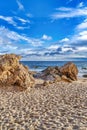 Sand and rocks in Laguna Beach California with sea and cloudy blue sky views Royalty Free Stock Photo