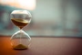 Sand running through the bulbs of an hourglass measuring the passing time in a countdown to a deadline, on a blur background with Royalty Free Stock Photo