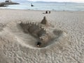 A sand sculpture in the shape of a dragon that exhales fire from the mouth located on the beach Royalty Free Stock Photo