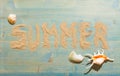 Sand and shells on blue planked wood with the word Summer. Background with copy space. Top view Royalty Free Stock Photo