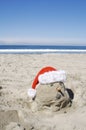 A Sand Snow Man on the Beach with a Santa Hat for Christmas