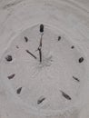 Sand and stick beach clock face 10 o clock Royalty Free Stock Photo