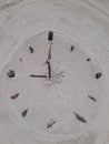 Sand and stick beach clock face 9 o clock Royalty Free Stock Photo