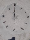 Sand and stick beach clock face 6 o clock Royalty Free Stock Photo