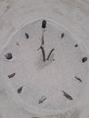 Sand and stick beach clock face 1 o clock Royalty Free Stock Photo