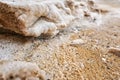 Sand and stones covered with crystalline salt crust on shore of Dead Sea, closeup detail Royalty Free Stock Photo