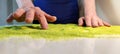 Sand therapy for the elderly, the hands of an elderly woman draw on the green kinetic sand