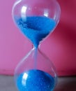 sand timer  blue flask with pink background hourglass time passing Royalty Free Stock Photo