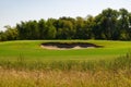 Sand trap on a golf course with trees in background Royalty Free Stock Photo