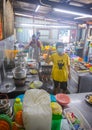 Sandakan, Malaysia - January 6, 2022: Inside the kitchen of a Chinese street food restaurant. Woman shows the peace sign. Typical Royalty Free Stock Photo