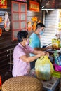 Sandakan, Malaysia - January 06, 2022: sales women packs the goods in a plastic bag. Fish market in Sabah, Borneo. The shops are