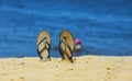 Sandal flip flop on the white sand beach with blue ocean background in vacations Royalty Free Stock Photo