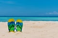 Sandal flipflops on a sandy ocean beach with blue sea and blue b Royalty Free Stock Photo