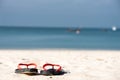 The sandals places on white-yellow sand beach Royalty Free Stock Photo