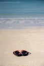 The sandals places on white-yellow sand beach Royalty Free Stock Photo