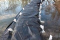 Flooded sandbags flood protection covered with nylon and surrounded with sandbags