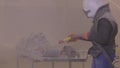 The man is sandblasting the detail. Sandblast metal parts. Sandblasting gun