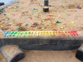 Sandbox for children with sand and shovels, rakes, molds. game for kids in the playground - dig and build Easter cakes. Royalty Free Stock Photo