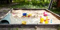 Sandbox outdoor. Children`s wooden sandbox with various toys for the game Royalty Free Stock Photo