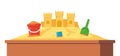 Sandbox with pile of sand, sand castle and children toys in flat style. Sandpit with kids shovel, bucket on pile of yellow powder