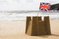Sandcastle On Empty British Beach With UK Union Jack Flag Flying Royalty Free Stock Photo