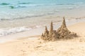 Sandcastle on sandy beach near waving blue sea Royalty Free Stock Photo