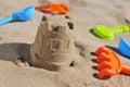 Sandcastle and toy shovels on the sand of a beach
