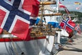 Norwegian flags waving fom the aft of several wooden boats..
