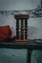 Hourglass made of wood in front of a white brick wall