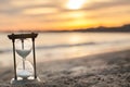 A sandglass, modern hourglass or egg timer with shadow showing the last second or last minute or time out.