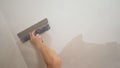 Sanding the ceiling before painting. A worker cleans the ceiling with a spatula. Hands of Workers are repairing the Royalty Free Stock Photo