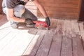 Sanding hardwood floor with the grinding machine. Repair in the apartment, country house,patio. Carpenter doing parquet Royalty Free Stock Photo