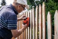 Sanding and preparing wooden fence for painting