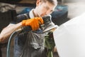 Sanding of uneven elements of the car after painting and varnishing. Vehicle repair in service station. Royalty Free Stock Photo