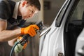 Sanding of uneven elements of the car after painting and varnishing. Vehicle repair in service station.