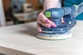 Sanding wooden furniture using an electric hand grinder Royalty Free Stock Photo