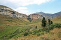 SANDSTONE CLIFFS TOWERING OVER SLOPES AND VALLEYS IN THE SOUTH AFRICAN DRAKENSBERG MOUNTAIN RANGE Royalty Free Stock Photo