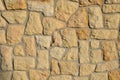 Sandstone folded wall joints filled with mortar yellow beige irregular stones front sun view clean work Royalty Free Stock Photo