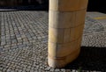 Sandstone lookout column made of sandstone blocks in the shape of a cylinder or ellipse. standing on a sidewalk of granite cubes.
