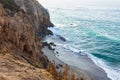 Sandstone path overlooking cliff side, pacfic ocean expanse, and waves on the shore