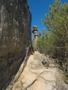 Sandstone rock pillar in spring landscape r Lusatian Mountains with fresh deciduous and spruce tree forest. Blue sky